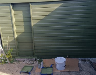 a garage door with a bucket of paint and a bucket of paint