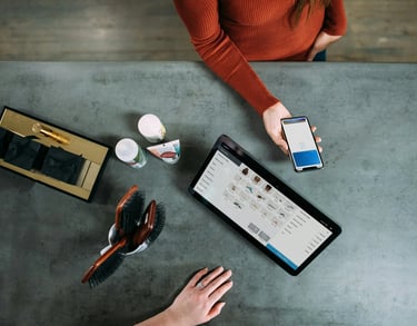 a woman sitting at a table with a tablet and a tablet
