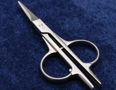 A detailed shot of neurosurgical forceps resting on a dark blue velvet surface. The lighting catches the polished steel edges, showcasing the fine tips and high-quality finish of the Pakistani-made instrument.