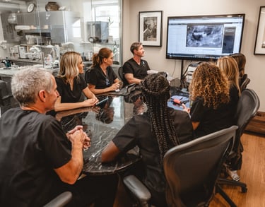 A professional dental team in a morning huddle meeting.