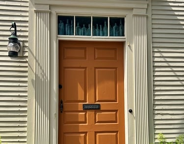 A New England home with an orange door