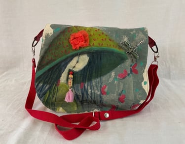 Hand-painted artistic crossbody bag featuring a girl in a hat with 3D floral and dragonfly accents.