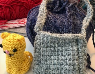 Figura de gato amarillo tejida a crochet, hecha a mano, un bolso gris tejido en crochet tunecino