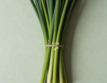 A top-down view of a neatly arranged bouquet being tied with a simple jute string on a pale green surface, clean lines and modern aesthetic, North American context.