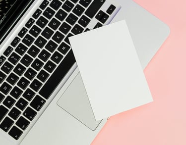 a laptop computer and a note pad on a pink background, showing communication with researchers