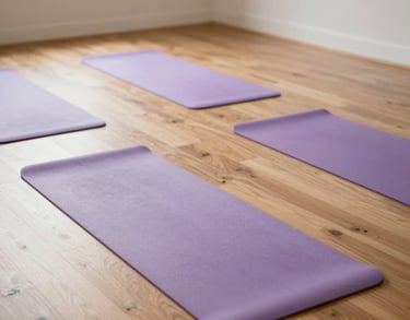 An interior shot of a spacious yoga studio in a North American retreat, with light wood floors and several pale purple yoga mats neatly arranged. Bright natural light fills the room.