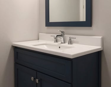 Interior view of an accessible bathroom in a North American home, featuring high-quality fixtures, deep charcoal navy accents, and clean design.