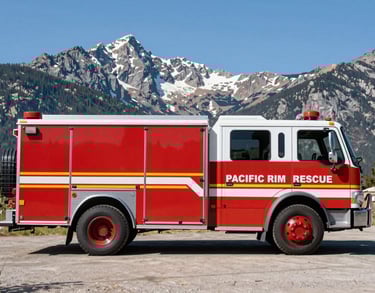 A professional rescue vehicle with Pacific Rim Rescue branding parked in a scenic North American mountain landscape, clear blue sky, sharp focus.