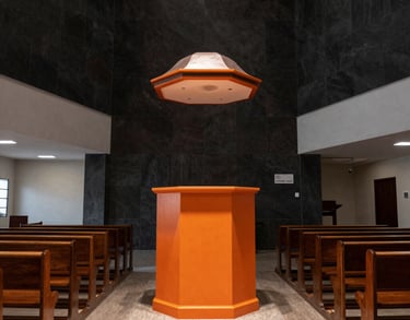Wide shot of the ADMVA church interior in Rio de Janeiro, with modern dark architecture and bright orange highlights on the pulpit.