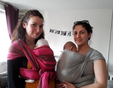 deux amies portant leurs bébés en écharpe à domicile