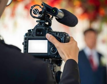 Event Photography a man in a suit and tie is holding a camera and recording a video camera