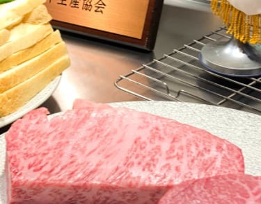 a table with a plate of raw wagyu meat