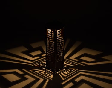 A decorative wooden lantern casting geometric shadow patterns on a surface in a dark room.