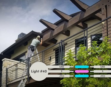 Professional installing outdoor soffit lighting on a modern balcony with wiring diagram.