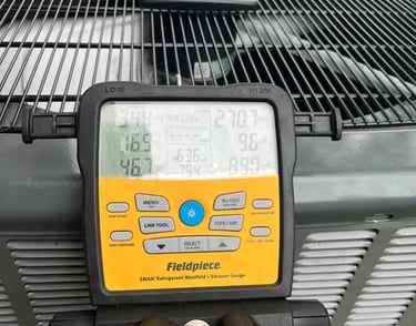 Technician checking refrigerant levels of split AC with gauge tools