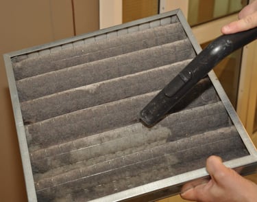 AC technician cleaning and replacing air filter in UAE home