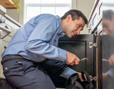 Plumber using advanced leak detection equipment to fix water leak in Dubai home