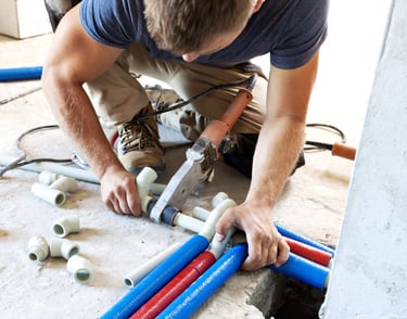 Professional plumber installing new PVC plumbing pipes in UAE building