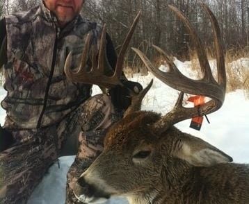 Saskatchewan whitetail hunts - beautiful whitetail buck with hunter