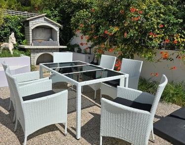 The photograph shows a dining set in the courtyard of Lokva Rogoznica's house and a barbecue.