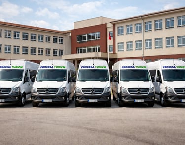 A fleet of white Mercedes-Benz Sprinter shuttle vans for Procesa Turizm transport services.