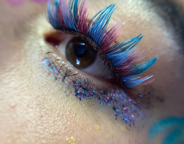 extensiones de pestañas vibrantes en azul y rosa con maquillaje de ojos con brillo
