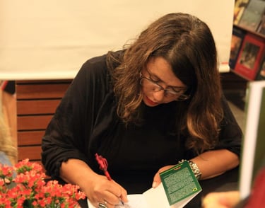 a woman is sitting at a table with a book