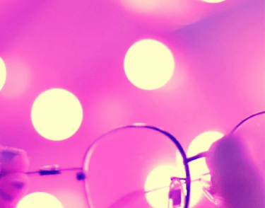 Lunettes sur fond rose lumineux symbolisant le changement de point de vue