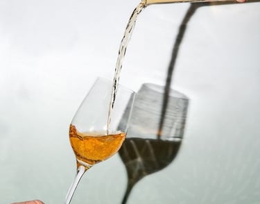 a person pouring a glass of wine into a glass