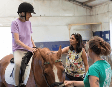 a women with stroke riding a horse