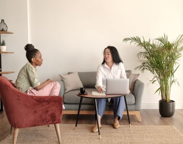 a woman sitting on a couch with a laptop computer