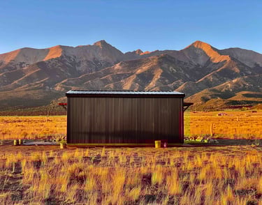 a small cabin with a mountain in the background