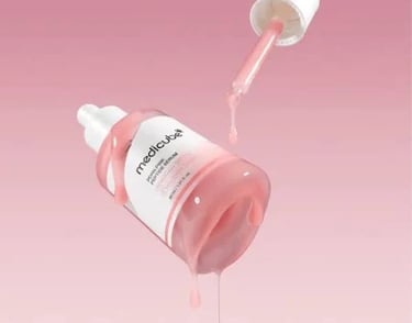 a bottle of pink liquid with a dropper in it