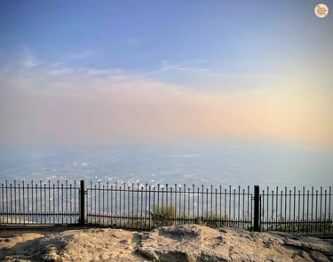Beautiful sunset at the horizon as seen from Nandi Hills near Bengaluru, casting golden light over misty valleys and hilltops