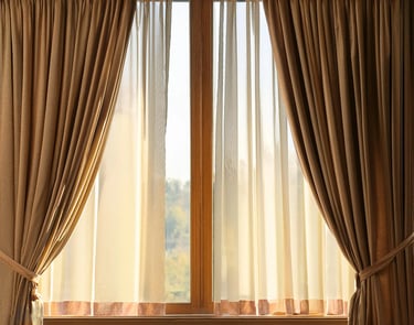 Rideaux retenus par des embrases devant une fenêtre à voilage blanc