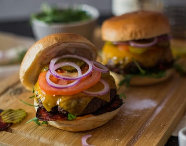 a couple of hamburgers on a cutting board