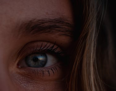 a woman with blue eyes and a toothbrush in her mouth