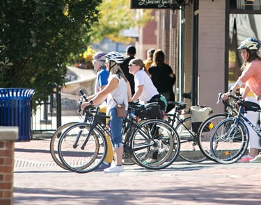 4 women on bikes stopped at a stop light