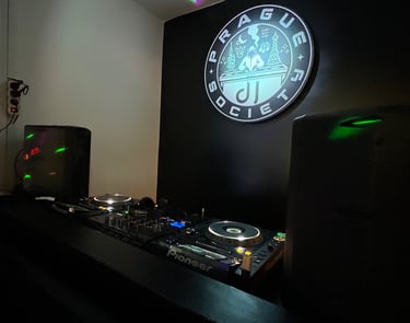 DJ Society booth with Pioneer setup and studio logo illuminated.