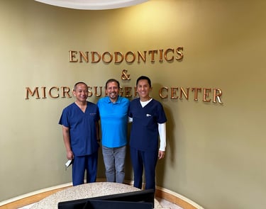 three of our doctors smiling at  Endodontics and Microsurgery Center lobby