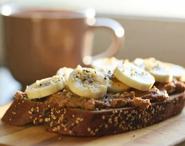 Tostada de pan de semillas con mantequilla de almendras casera, rodajas de plátano y semillas de cáñamo