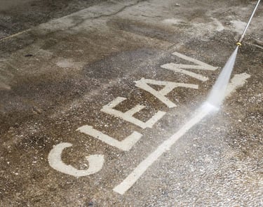 Clean written on to a concrete walk way by a pressure washing services pressure washing worker