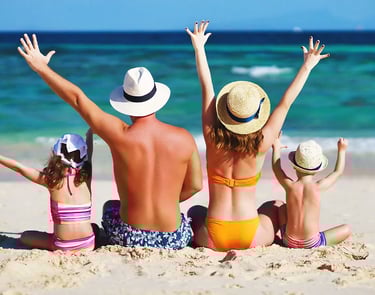 a family of four children sitting on a beach