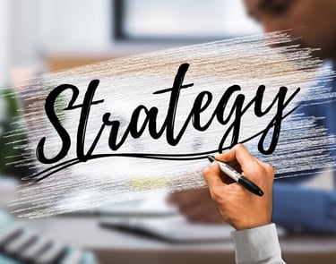 Hand writing the word Strategy on a digital glass board in a corporate business office setting.