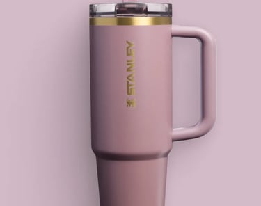 a pink Stanley mug with a gold rim and a pink mug
