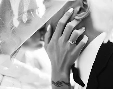 a bride and groom share a kiss under a veil