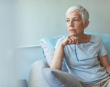 Mujer mayor con expresión pensativa, preocupada por las enfermedades neurodegenerativas. La estimula