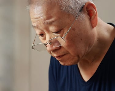 Close-up of artisan’s face, deeply focused while working on a teapot