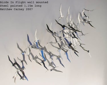 Steel sculpture of a flock of shearwaters in flight