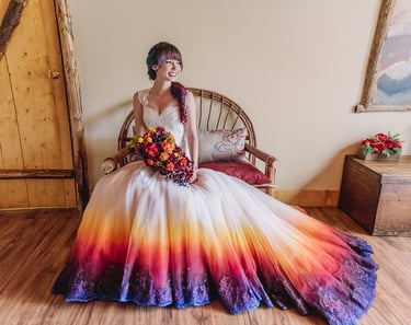 Bride in a sunset colored wedding dress with a matching bouquet and hair